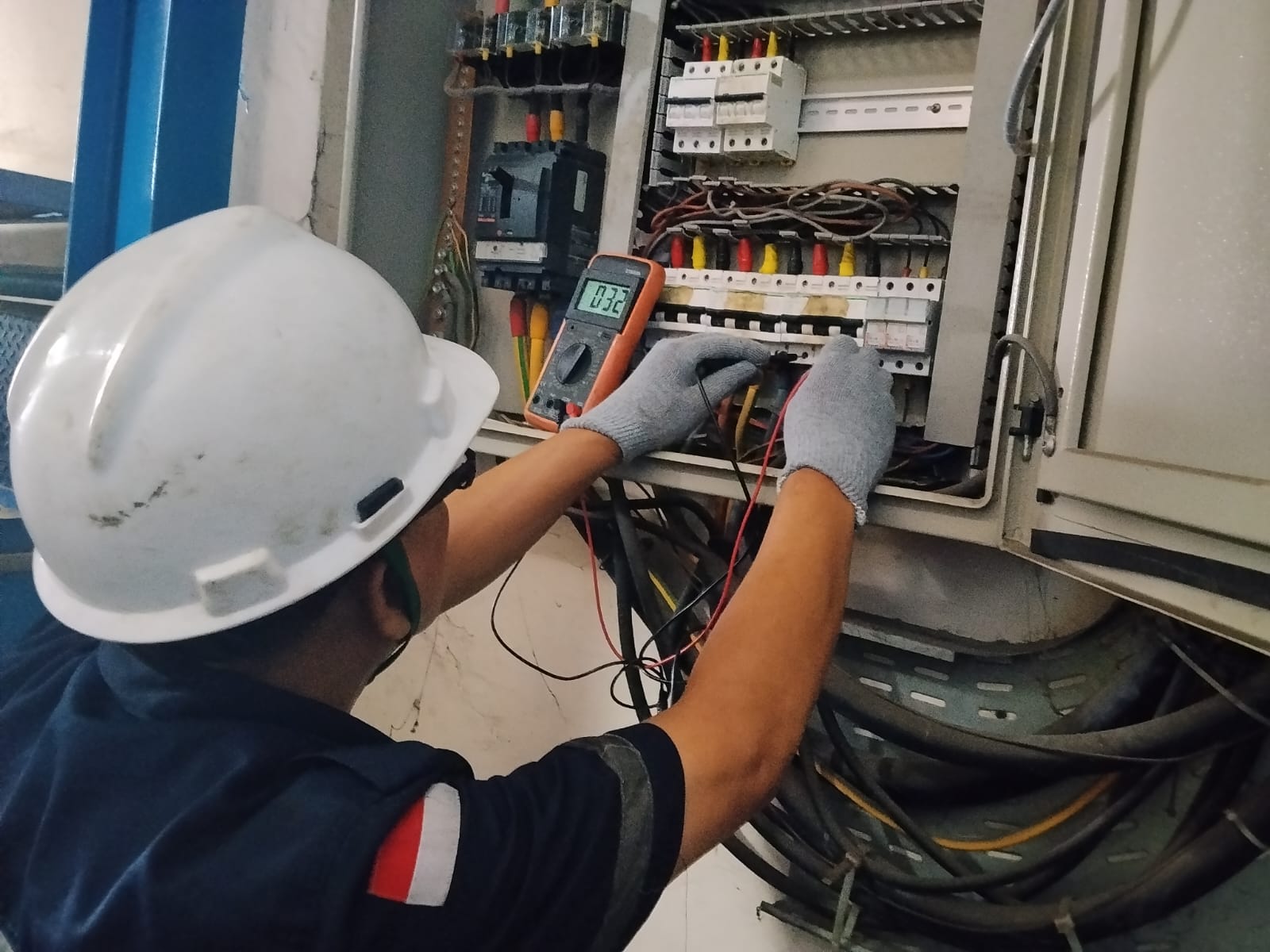 Teknisi melakukan pemeriksaan panel listrik